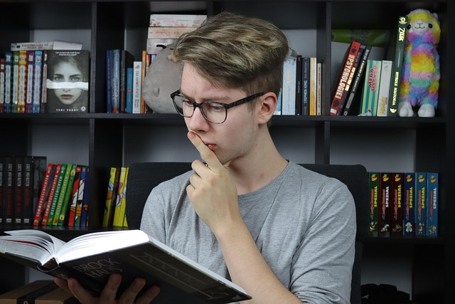 student reading FAQ on a laptop with course notes in a dark modern study space